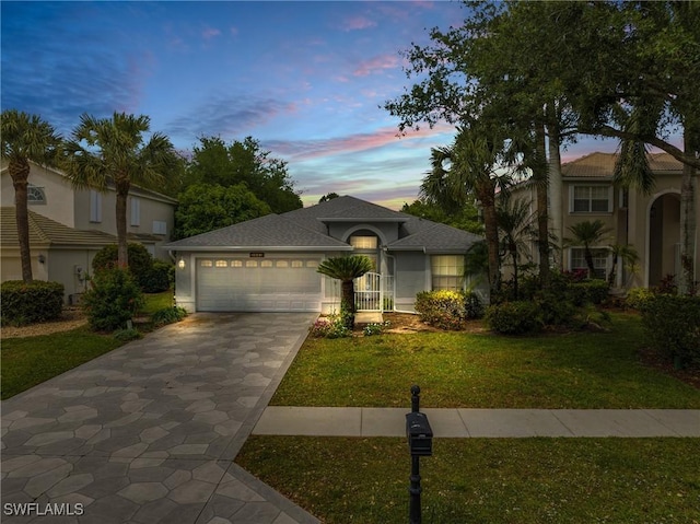 view of front of home with a garage and a lawn