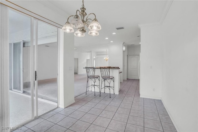 unfurnished dining area featuring ornamental molding, a chandelier, and light tile patterned flooring