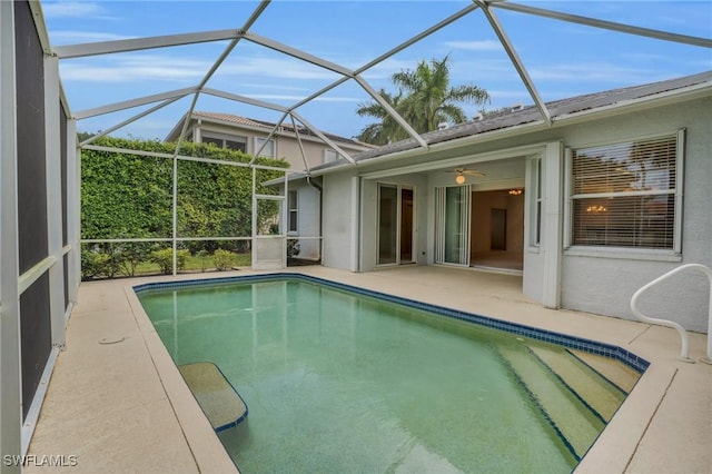 view of swimming pool with a patio, ceiling fan, and glass enclosure