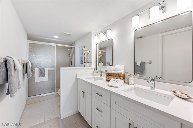 bathroom featuring vanity, toilet, and a shower with door