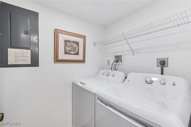 clothes washing area with washing machine and clothes dryer and electric panel