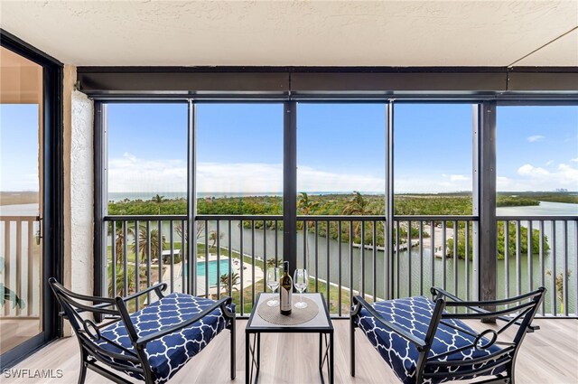 sunroom / solarium featuring a water view