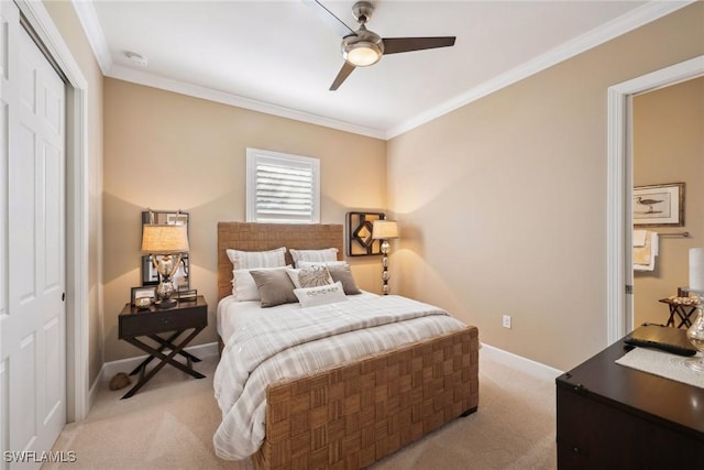 carpeted bedroom with a closet, ceiling fan, and crown molding