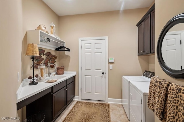 washroom with washer and dryer, sink, light tile patterned flooring, and cabinets