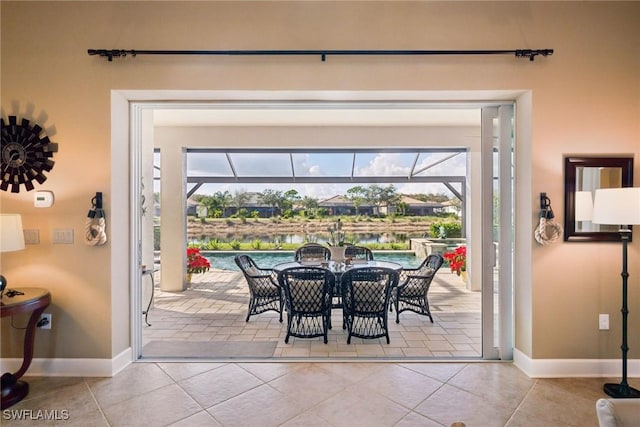 entryway featuring a water view, light tile patterned floors, and a wealth of natural light