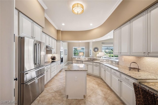 kitchen with white cabinets, light stone counters, kitchen peninsula, stainless steel fridge, and a kitchen island