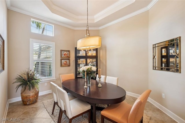 dining space featuring a tray ceiling, crown molding, and light tile patterned flooring