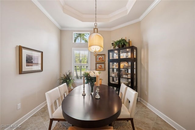 tiled dining area featuring a tray ceiling and ornamental molding