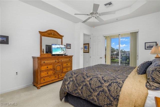 carpeted bedroom with a raised ceiling, ceiling fan, and access to exterior