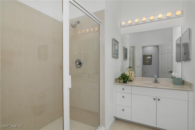 bathroom with tile patterned floors, vanity, and a shower with door