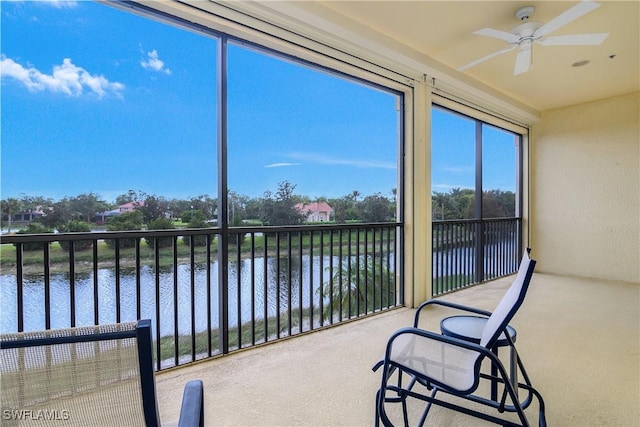 sunroom / solarium featuring ceiling fan and a water view