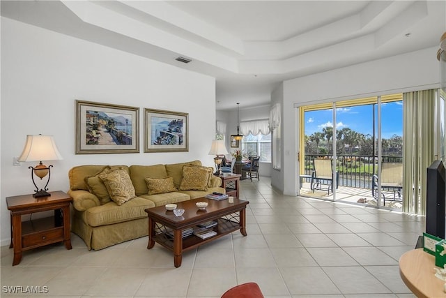 tiled living room featuring a tray ceiling