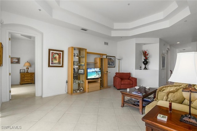 tiled living room with a tray ceiling