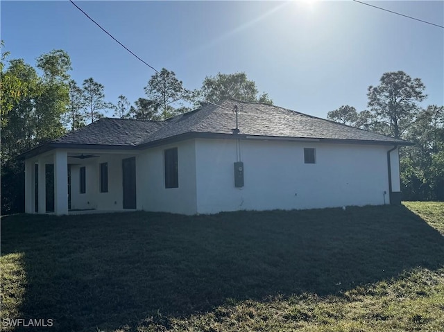 view of property exterior with a lawn and ceiling fan