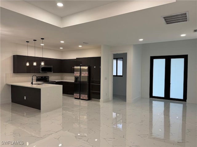 kitchen featuring sink, kitchen peninsula, hanging light fixtures, and appliances with stainless steel finishes