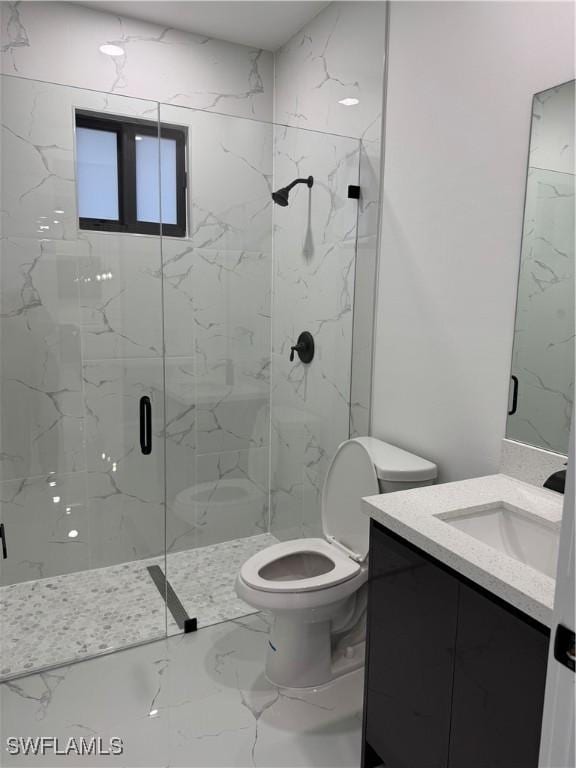 bathroom with vanity, toilet, and a shower with door