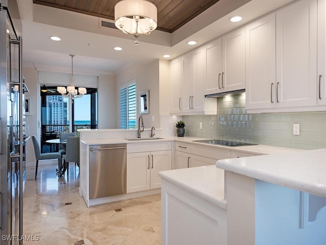 kitchen featuring an inviting chandelier, sink, stainless steel dishwasher, white cabinetry, and kitchen peninsula