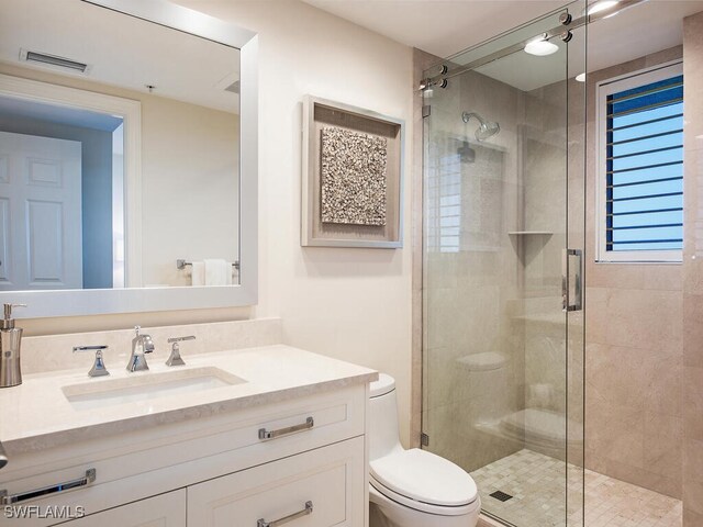 bathroom featuring walk in shower, vanity, and toilet