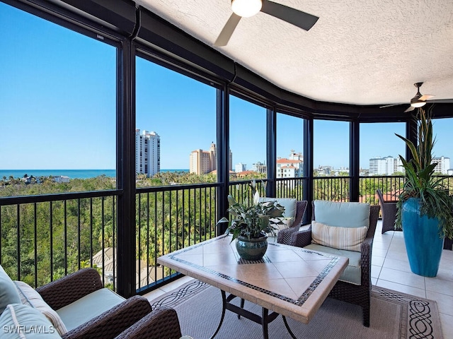 sunroom / solarium with a water view, a wealth of natural light, and ceiling fan