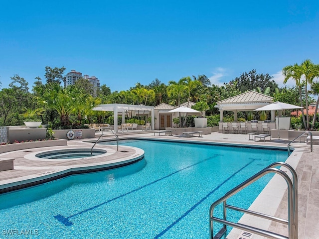 view of swimming pool with a patio area and an in ground hot tub