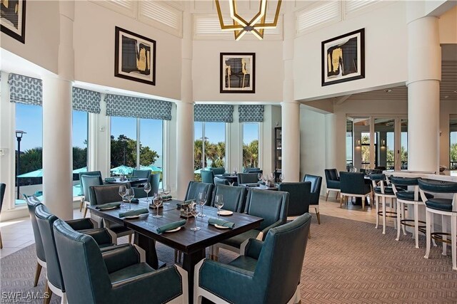 dining space featuring a chandelier, a high ceiling, and tile patterned floors