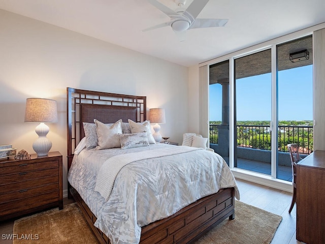 bedroom with hardwood / wood-style flooring, a wall of windows, ceiling fan, and access to outside