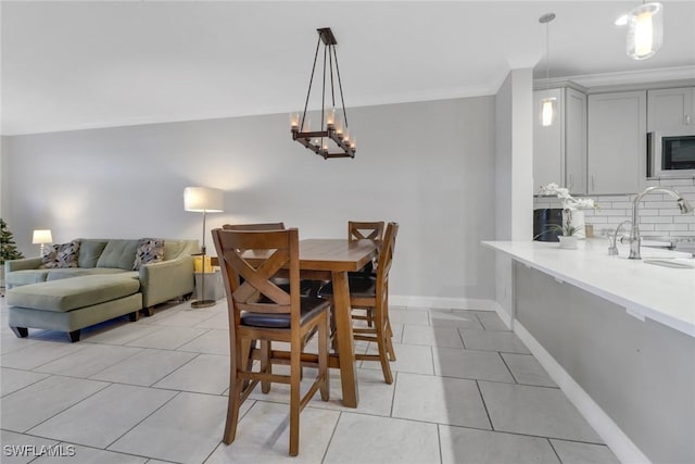 dining area featuring ornamental molding, baseboards, and light tile patterned floors