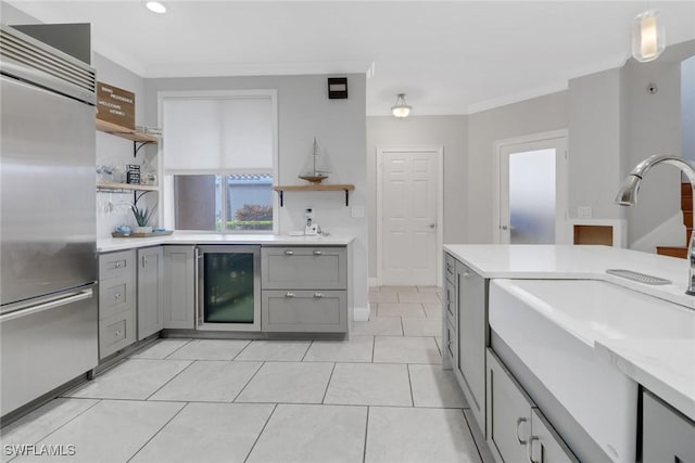 kitchen featuring stainless steel built in refrigerator, light countertops, beverage cooler, and open shelves