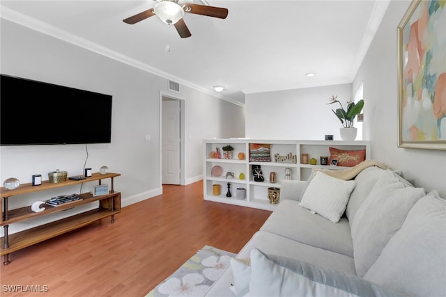 living room with visible vents, ornamental molding, ceiling fan, wood finished floors, and baseboards