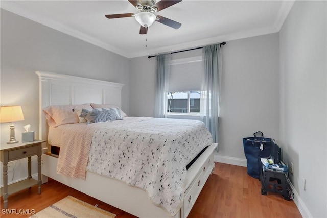 bedroom with ornamental molding, wood finished floors, a ceiling fan, and baseboards