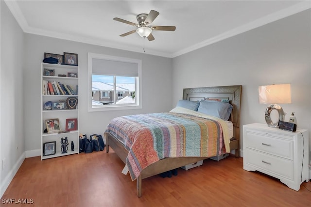 bedroom featuring ornamental molding, light wood-style flooring, and a ceiling fan