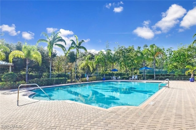 community pool featuring fence and a patio