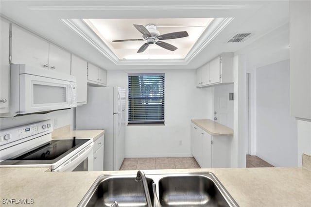 kitchen featuring a tray ceiling, ceiling fan, white cabinets, and white appliances