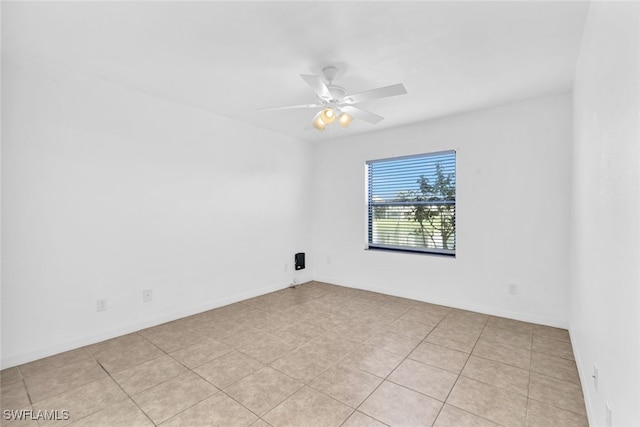 tiled empty room featuring ceiling fan