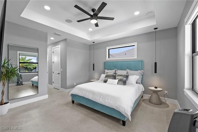 bedroom with ceiling fan and a tray ceiling