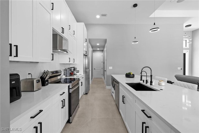 kitchen featuring sink, light stone countertops, decorative light fixtures, white cabinetry, and stainless steel appliances