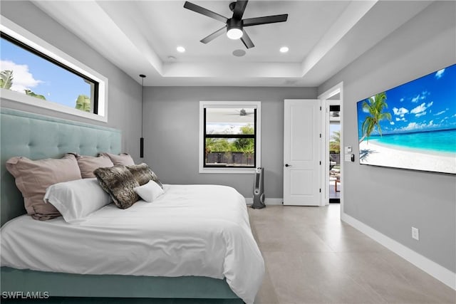 bedroom with a tray ceiling and ceiling fan