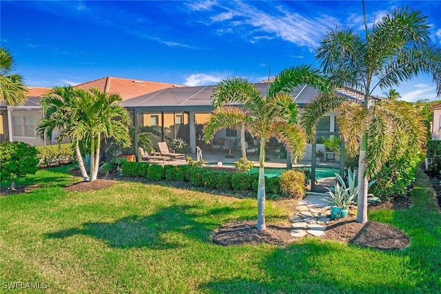 back of house featuring a patio, a lanai, and a lawn