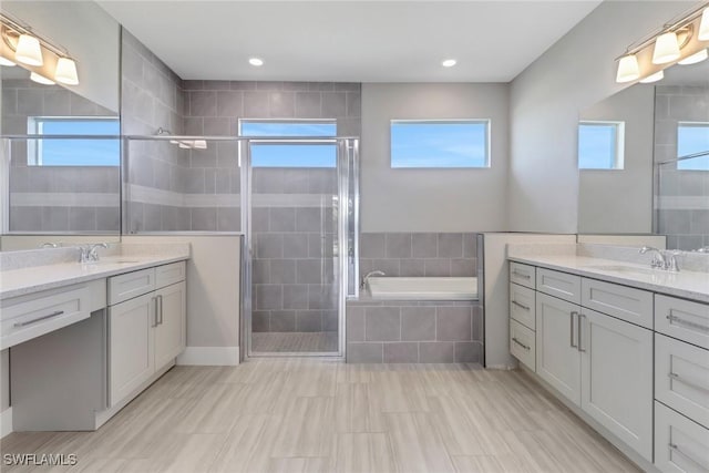 bathroom with vanity and independent shower and bath