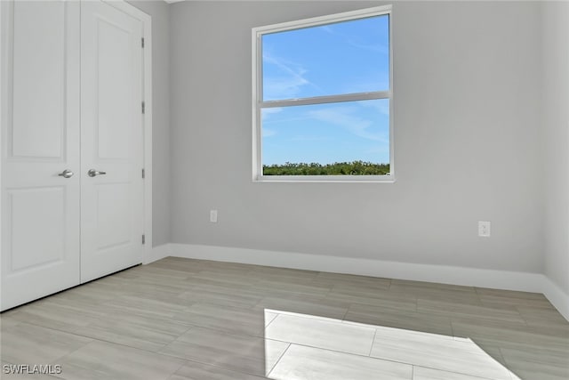 unfurnished bedroom with a closet and multiple windows