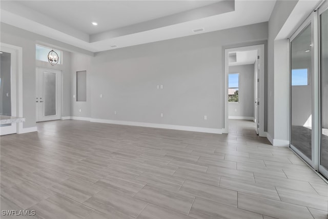 empty room featuring light hardwood / wood-style flooring and a notable chandelier