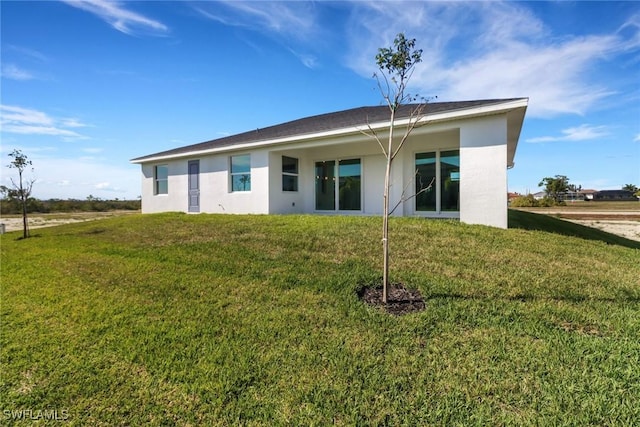 back of house with a lawn