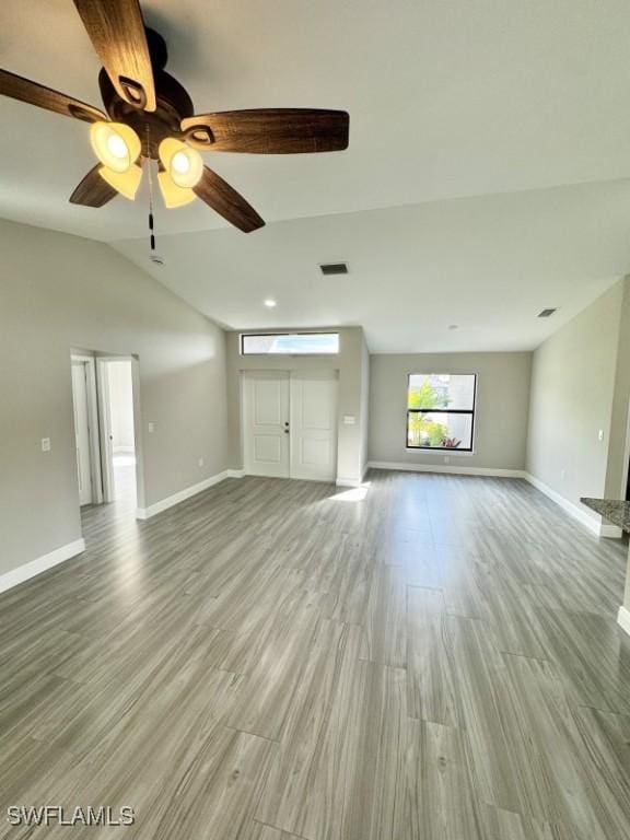 unfurnished living room featuring ceiling fan, vaulted ceiling, and hardwood / wood-style flooring