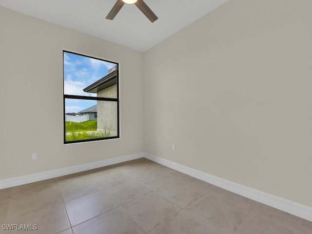 tiled spare room featuring ceiling fan