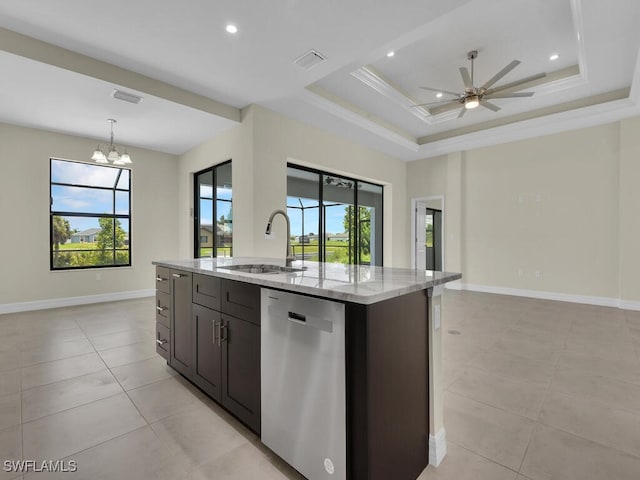 kitchen with ceiling fan with notable chandelier, sink, stainless steel dishwasher, light stone countertops, and an island with sink