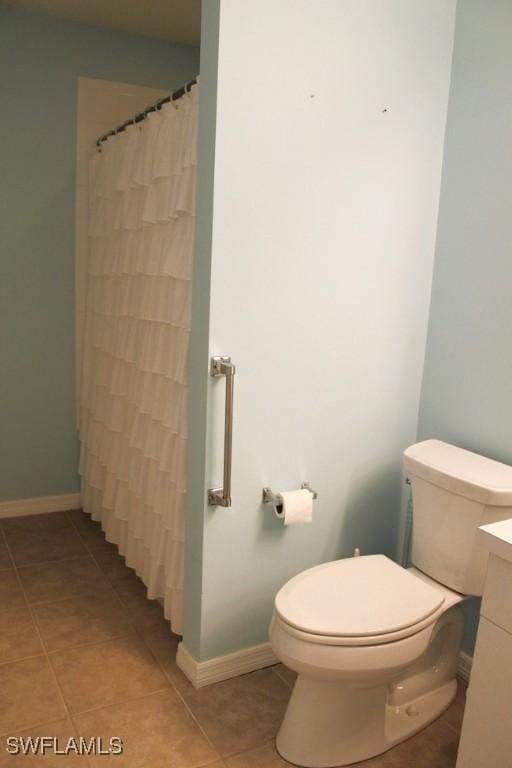 bathroom featuring tile patterned flooring, a shower with curtain, vanity, and toilet