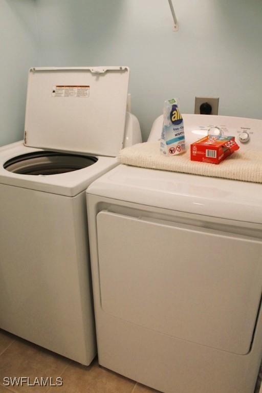 laundry area featuring separate washer and dryer and light tile patterned floors