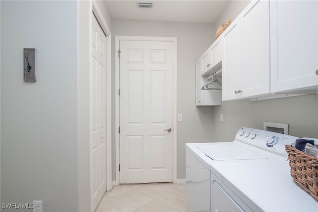 laundry area featuring washer and dryer, cabinets, and light tile patterned floors