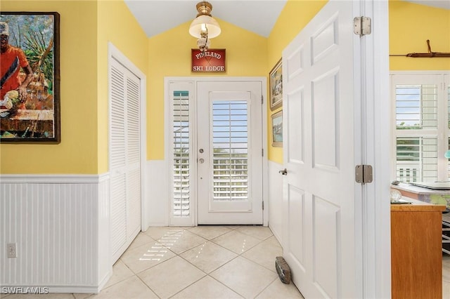 entryway featuring light tile patterned floors and vaulted ceiling