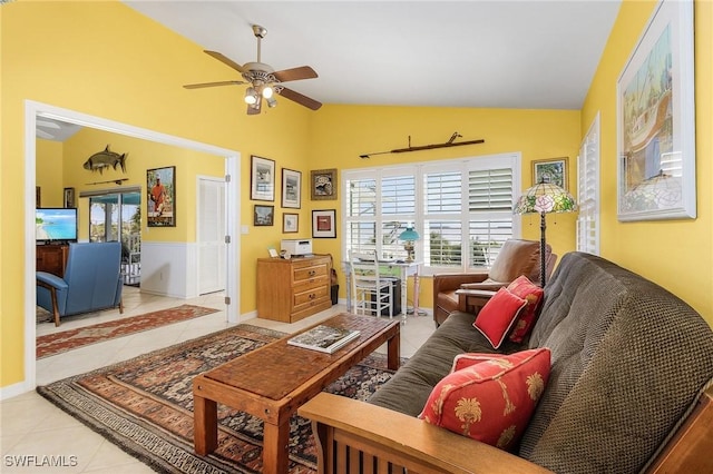 living room with ceiling fan, light tile patterned floors, and vaulted ceiling